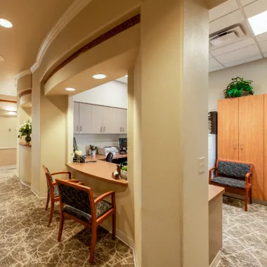 Alternate view of the main waiting area with seating, decorative ceiling, and bright natural light from multiple arched windows.