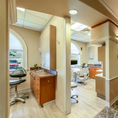 Expansive view of the lobby and reception area, featuring curved architectural details, couches, wall art, and the entrance door in the background.
