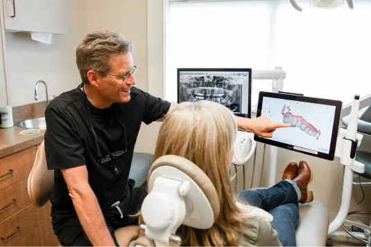doctor showing model of patient teeth