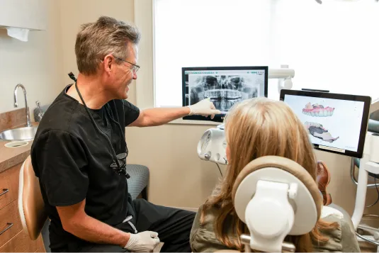 doctor showing patient teeth on monitor