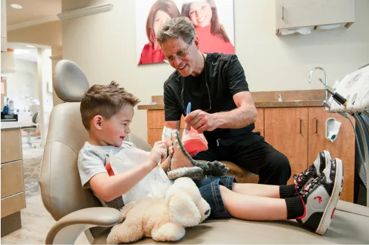 doctor showing kid how to brush