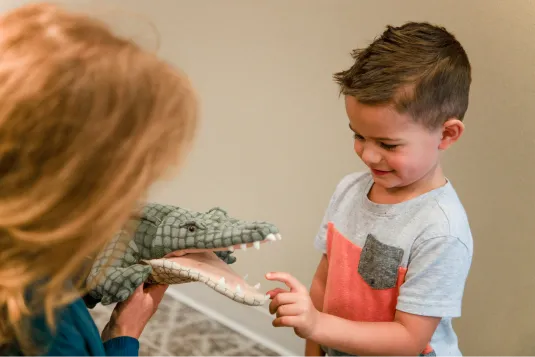 kid playing with aligator