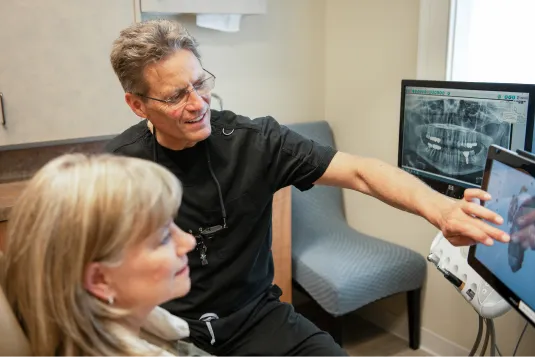 doctor showing patient model of teeth