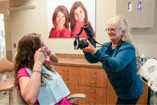 women taking picture of girl smiling