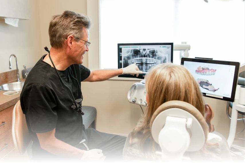 doctor showing patient teeth on monitor